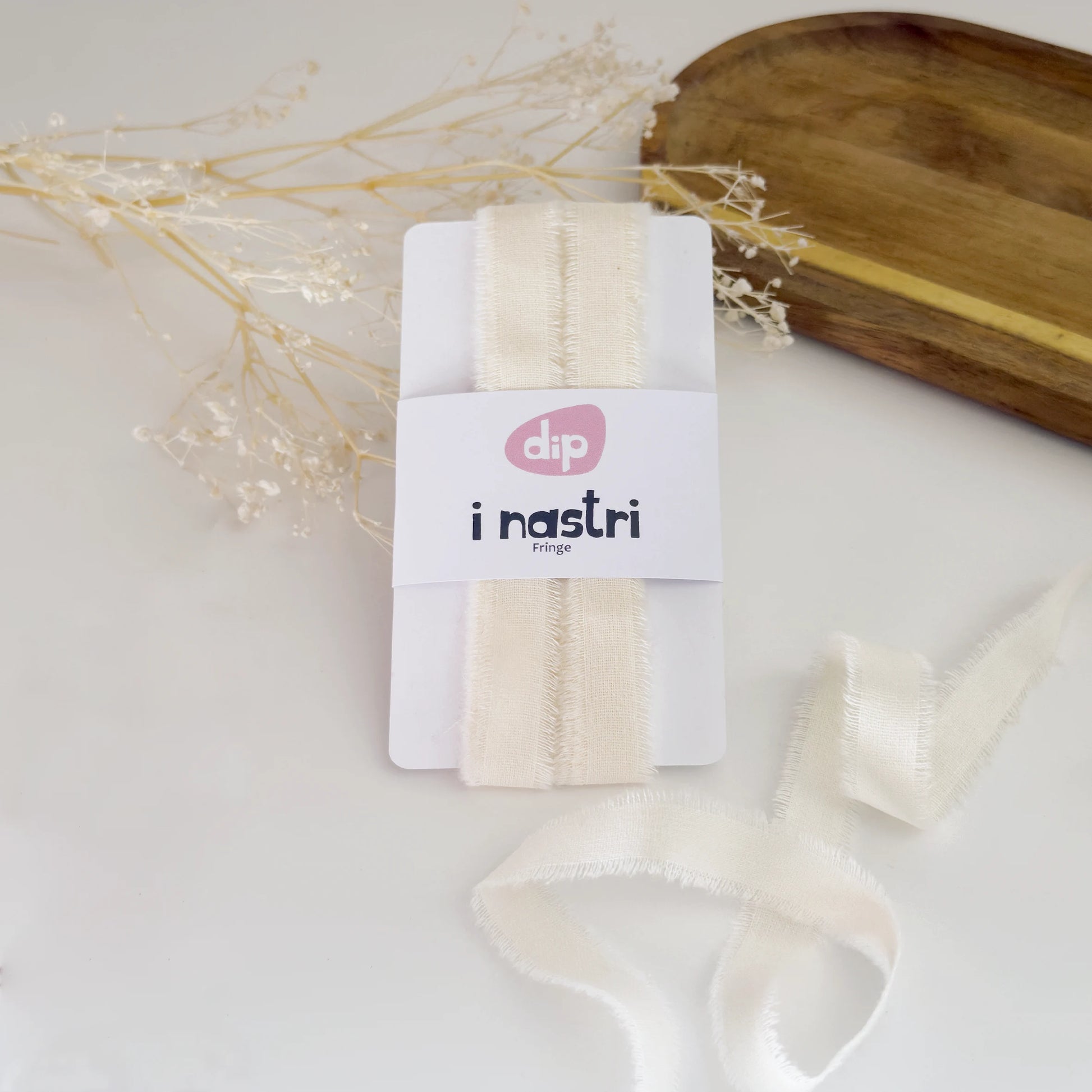 Nastro in morbido cotone color bianco avorio con bordi sfrangiati per confezioni regalo eco-friendly.