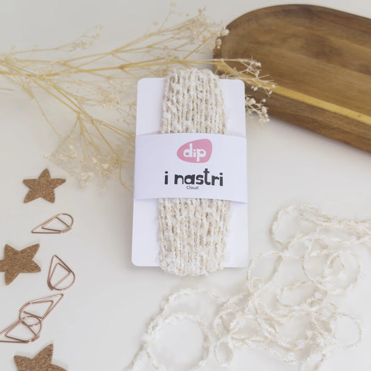Confezione di nastro decorativo Cloud cordino baker avorio con dettagli a batuffolo bianco su sfondo bianco con decorazioni naturali.