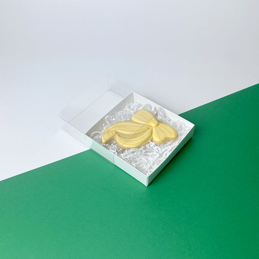 Scatola bianca quadrata con coperchio trasparente scorrevole per packaging di piccoli prodotti.