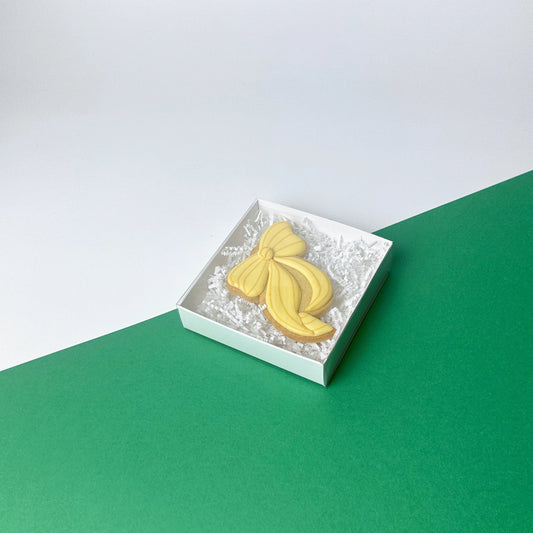 Scatola bianca quadrata con coperchio trasparente scorrevole per regali e pasticceria fine.